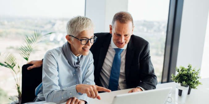 Older woman and male working on computer.