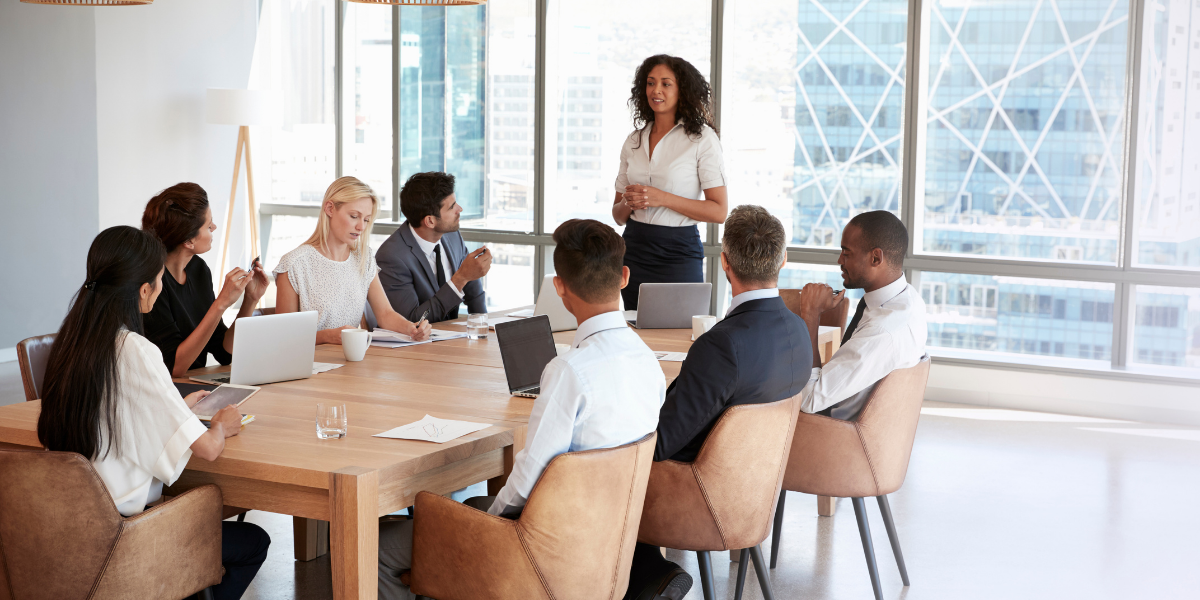 Professionals sitting in board room discussing.